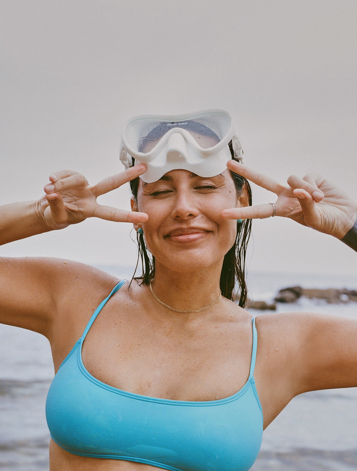 Khalyla Kuhn on a beach giving peace signs